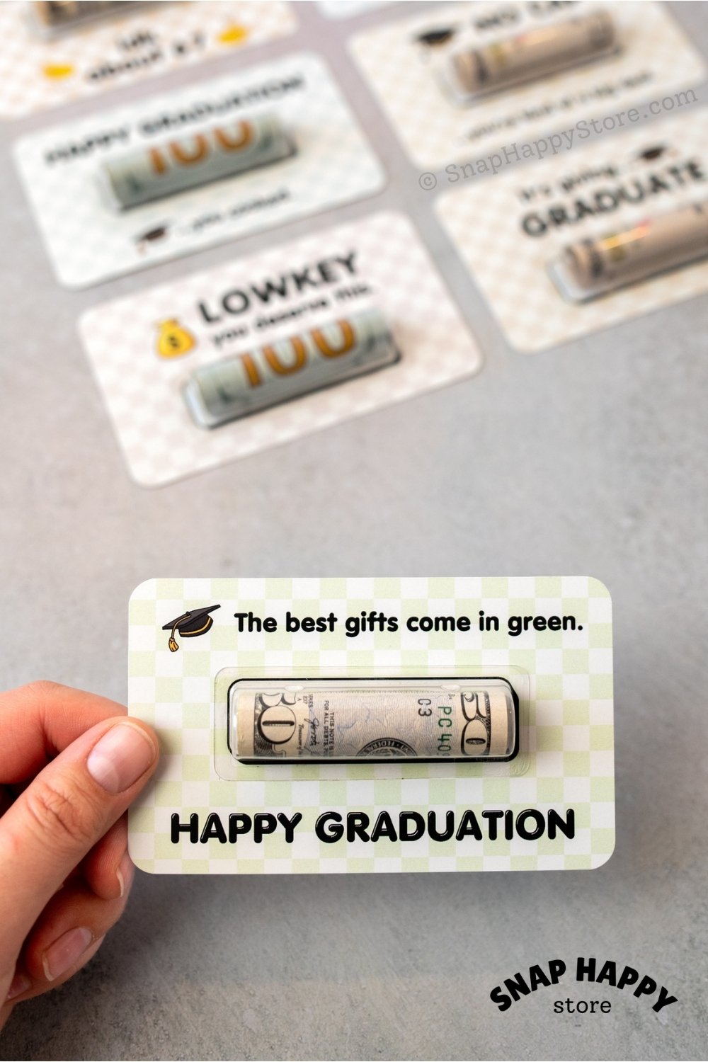 Graduation-themed gift card held by a hand with 'Happy Graduation' text on a gray background.